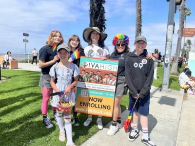 Marisol Marquez, Summer Sanders, and two young community members stand with students from IVA High's GSA Club before marching on Ocean Blvd. in the Long Beach Pride Parade.